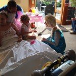 Princess Elsa speaking to a child sitting on a hospital bed