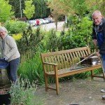 Man and woman cleaning a wooden garden bench