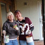 Two women holding paint pots and brushes