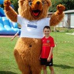 young boy posing with bear mascot