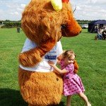 Little girl cuddling bear mascot
