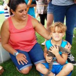 Mum and young boy holding lizard