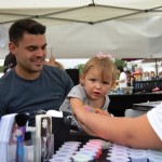 Little girl having glitter tattoo applied to arm