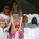 Two women posing with young children