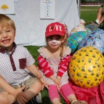 Little boy and girl sitting with giant decorated egg