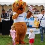 Bear mascot holding teddy