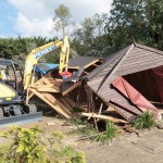 Digger demolishing shed