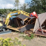 Digger demolishing shed