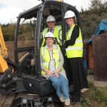 Man and two women posing by digger