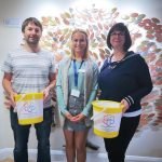 Cloud Margin holding St Clare fundraising buckets in front of the Memory Tree
