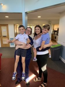 Katy pictured with her two sons Ollie and Max and St Clare Hospice nurse on the Inpatient Unit. They all smile at the camera.