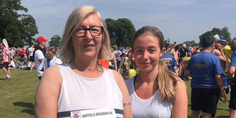 Michaela is pictured with her daughter Hannah at a running event. They smile at the camera.